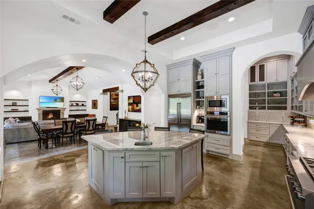 a large white kitchen with lots of counter space and windows