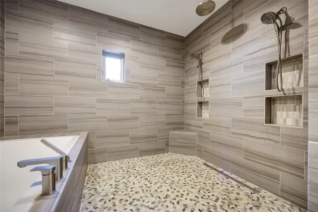 a spacious bathroom with a granite countertop sink a mirror and shower
