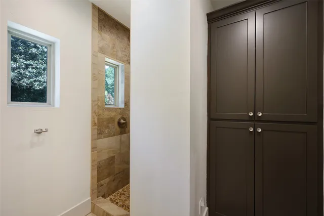 a bedroom with a bed and a dresser next to a window