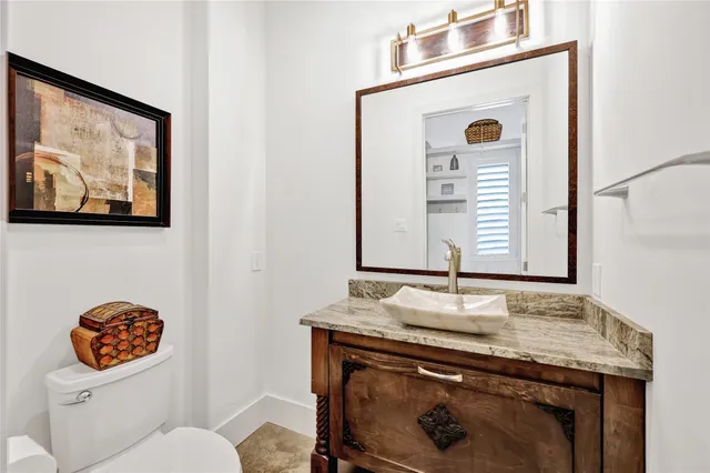 a bathroom with a granite countertop toilet sink and mirror
