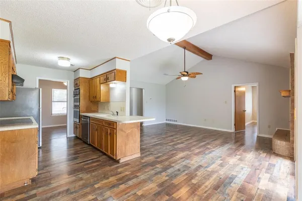a kitchen with stainless steel appliances granite countertop a sink a stove and a wooden floors