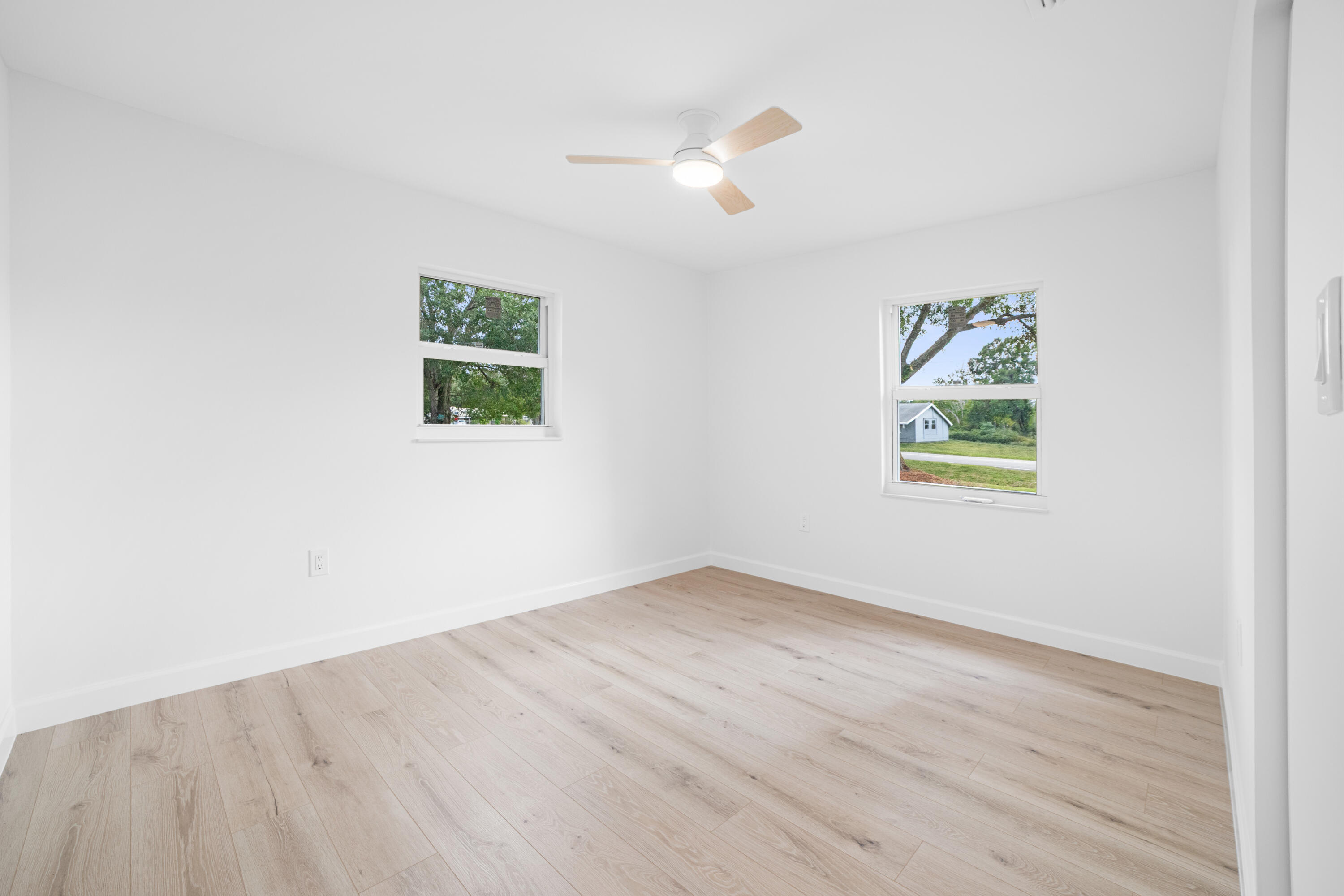 1008 Southwest 10th Street Okeechobee, FL 34974 - Photo 12 of 41 an empty room with wooden floor and window