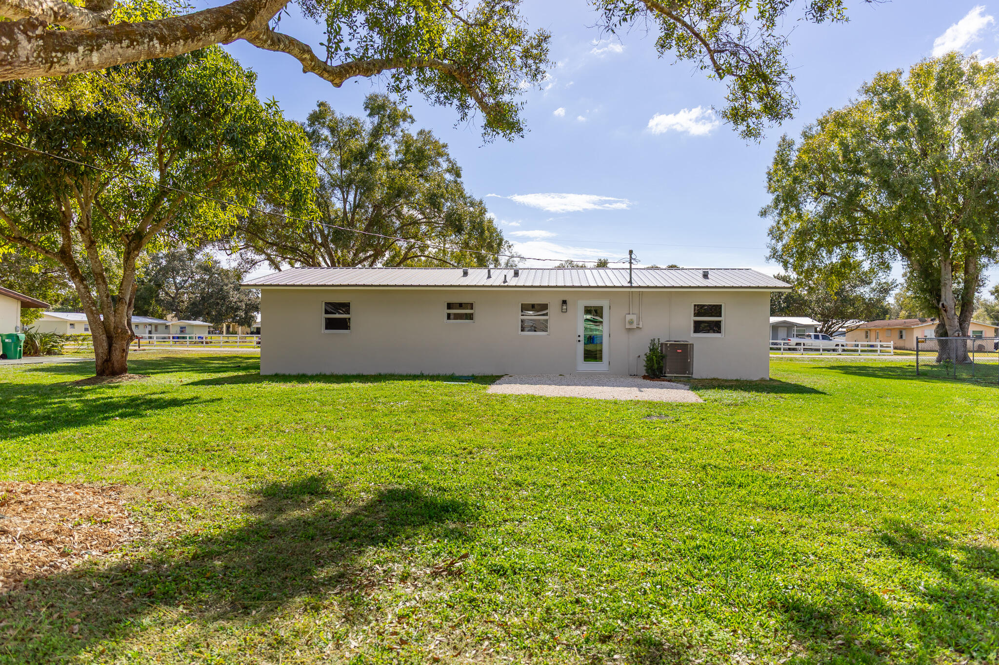 1008 Southwest 10th Street Okeechobee, FL 34974 - Photo 22 of 41 a view of a white house with a yard
