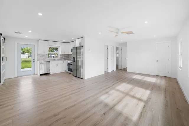 a view of a kitchen with a sink and a refrigerator