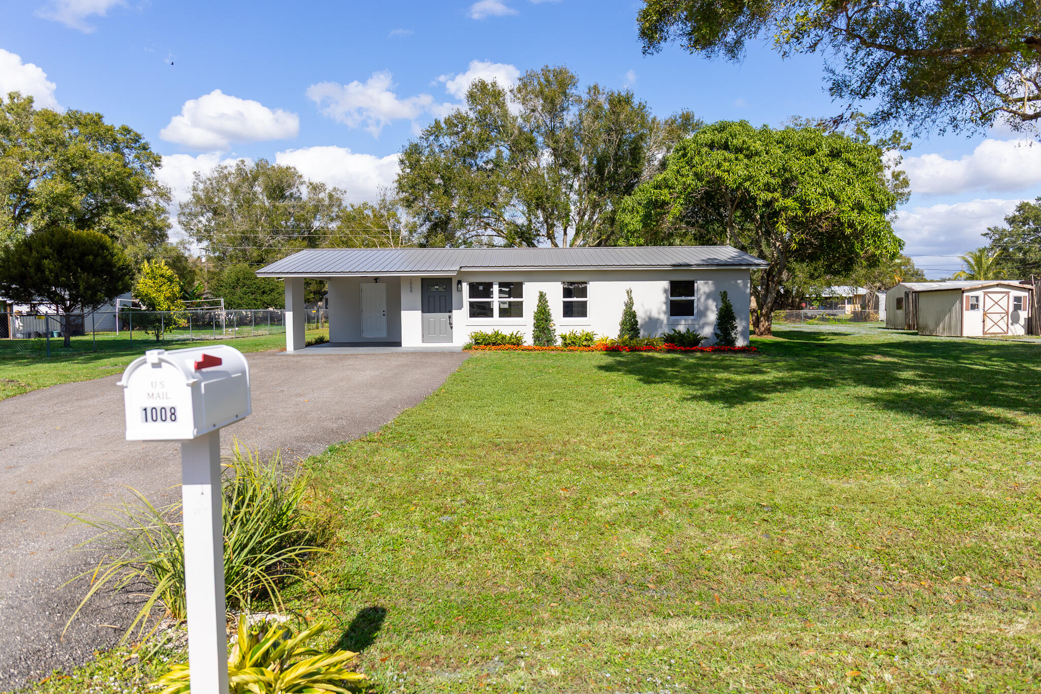 1008 Southwest 10th Street Okeechobee, FL 34974 - Photo 33 of 41 a front view of a house with a garden and trees