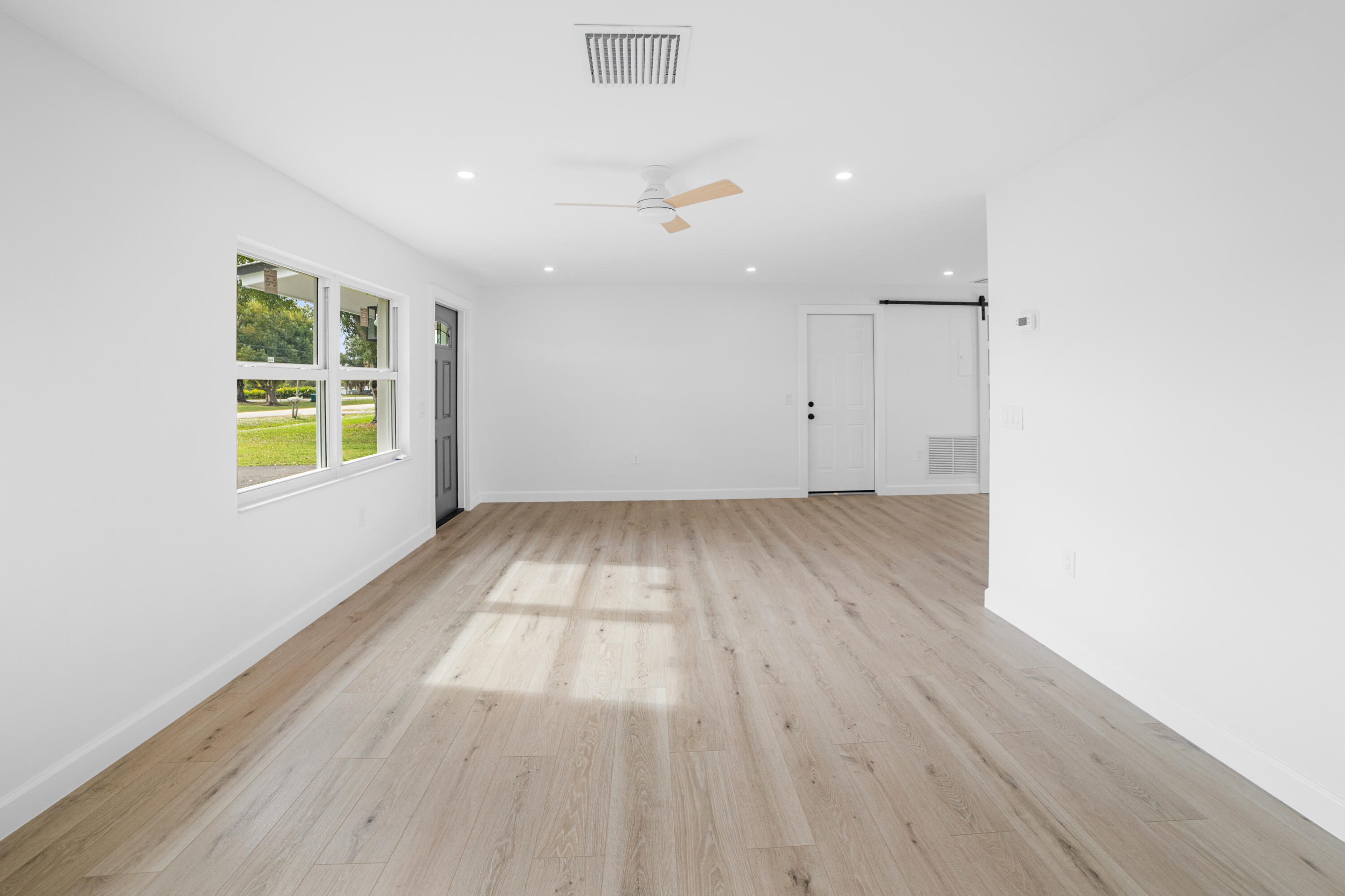 1008 Southwest 10th Street Okeechobee, FL 34974 - Photo 5 of 41 an empty room with wooden floor and windows