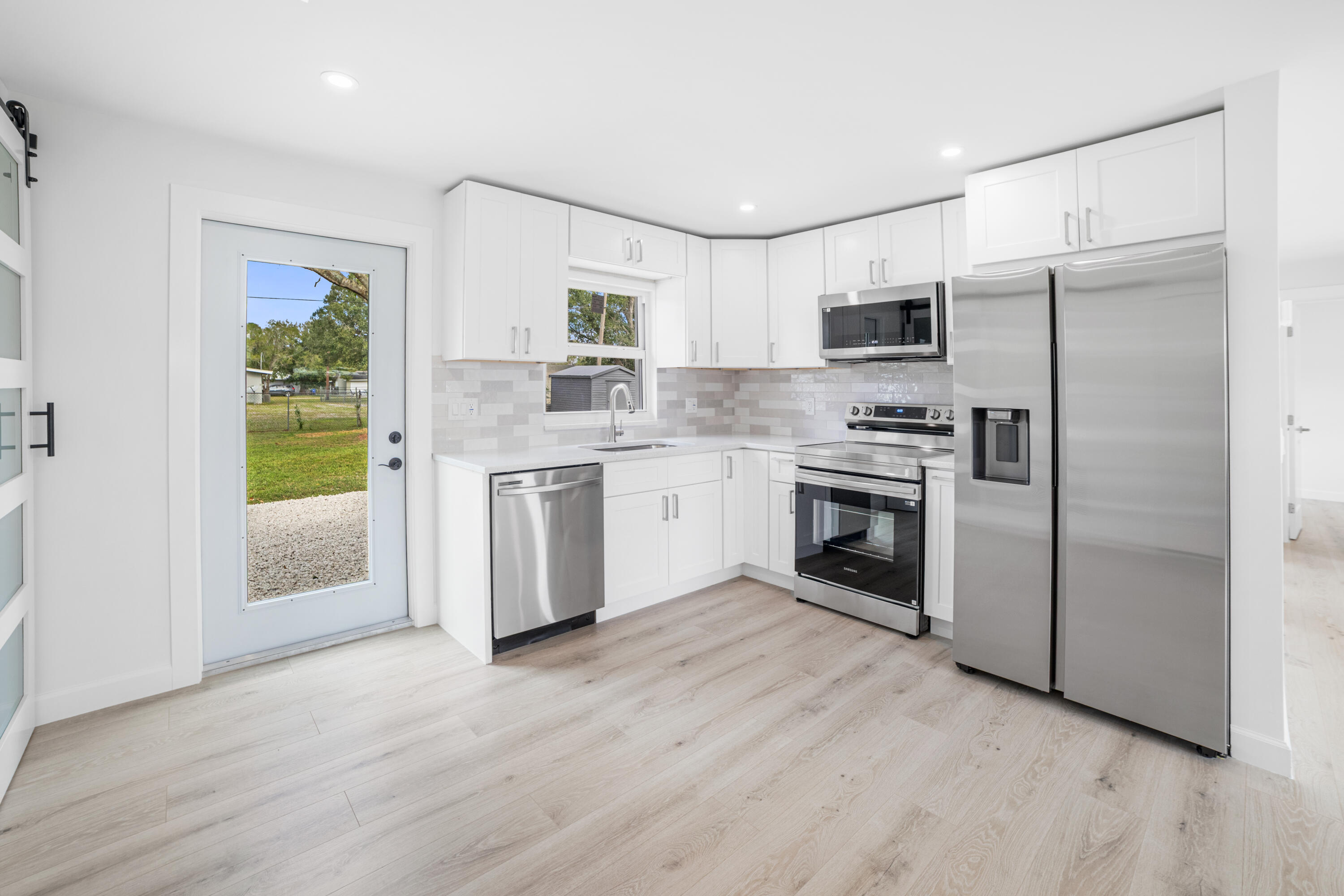 1008 Southwest 10th Street Okeechobee, FL 34974 - Photo 7 of 41 a kitchen with stainless steel appliances a stove a sink and a refrigerator