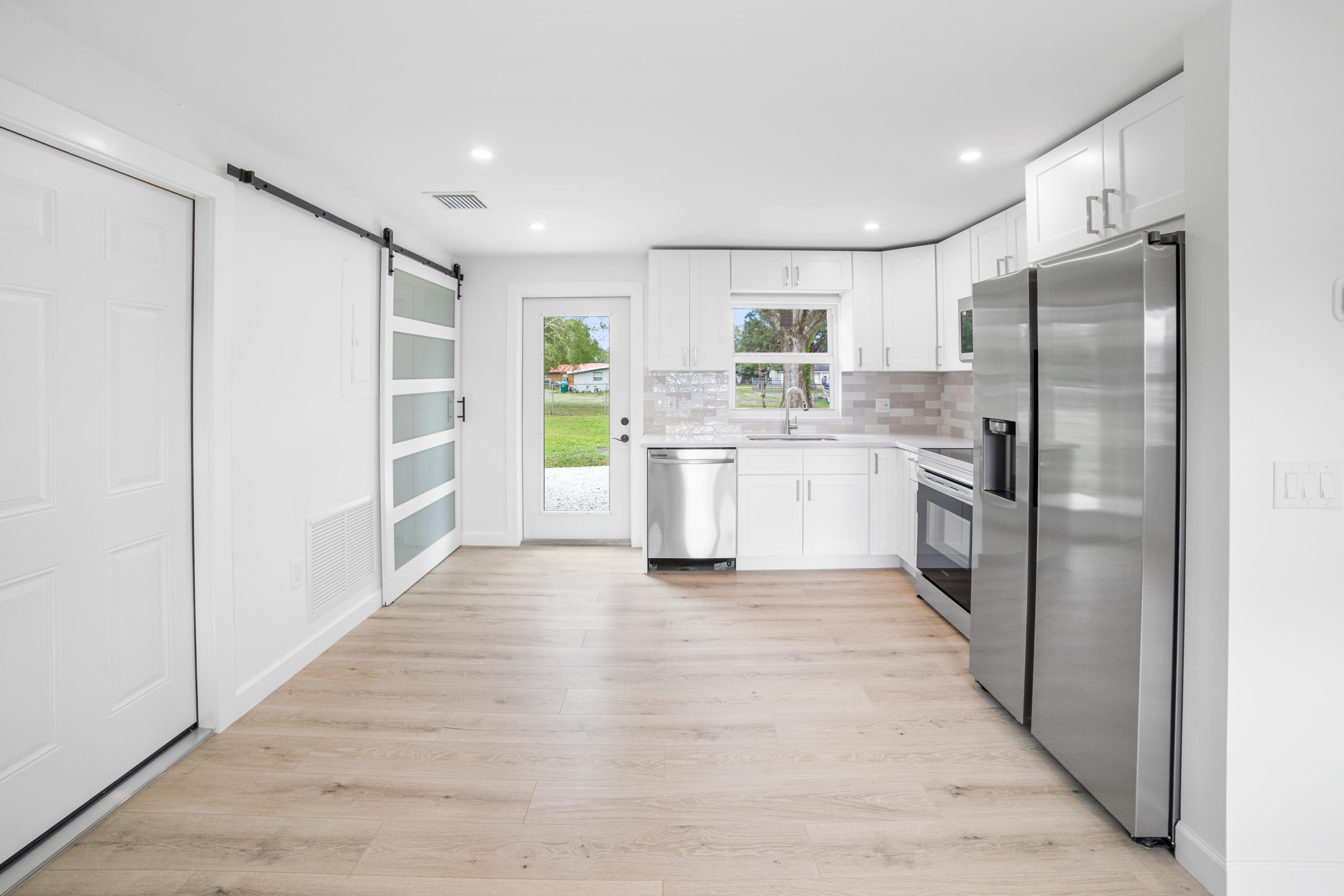 1008 Southwest 10th Street Okeechobee, FL 34974 - Photo 8 of 41 a kitchen with stainless steel appliances granite countertop a refrigerator and a stove top oven