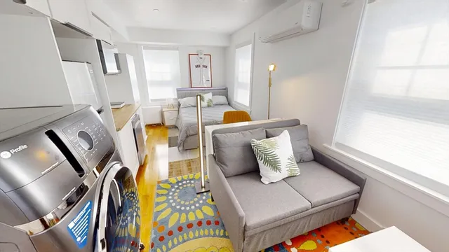 a living room with chairs and kitchen view