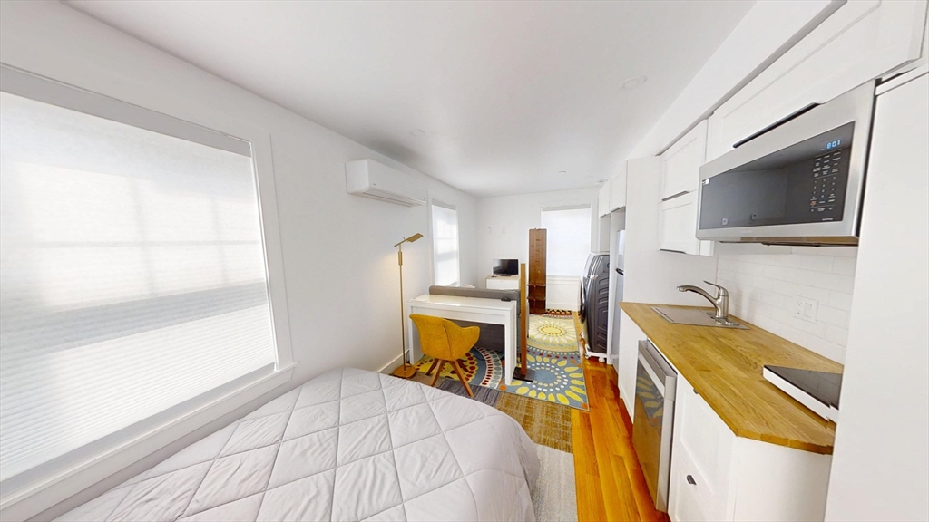 36 Shepard Street, Unit 2 Boston, MA 02135 - Photo 11 of 29 a bedroom with a bed and a flat tv screen on the dresser