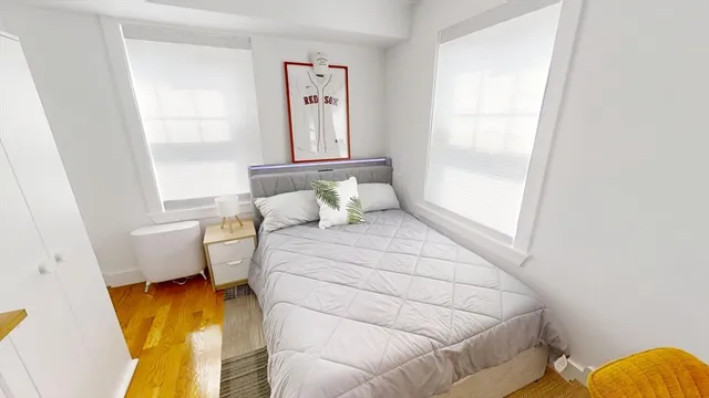 a bedroom with a bed and wooden floor