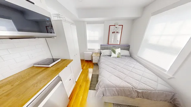 a bedroom with a bed and wooden floor