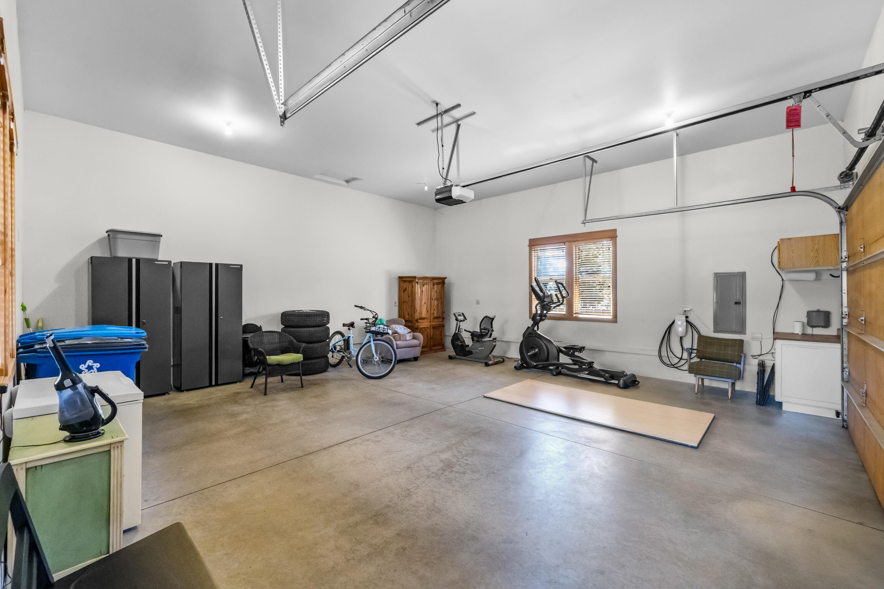 64145 Hunnell Road Bend, OR 97703 - Photo 38 of 65 Two-car garage offers generous space for parking and storage, with an EV charger and additional power connections that enhance the property?s functionality for everyday use, hobbies and Central Oregon living.