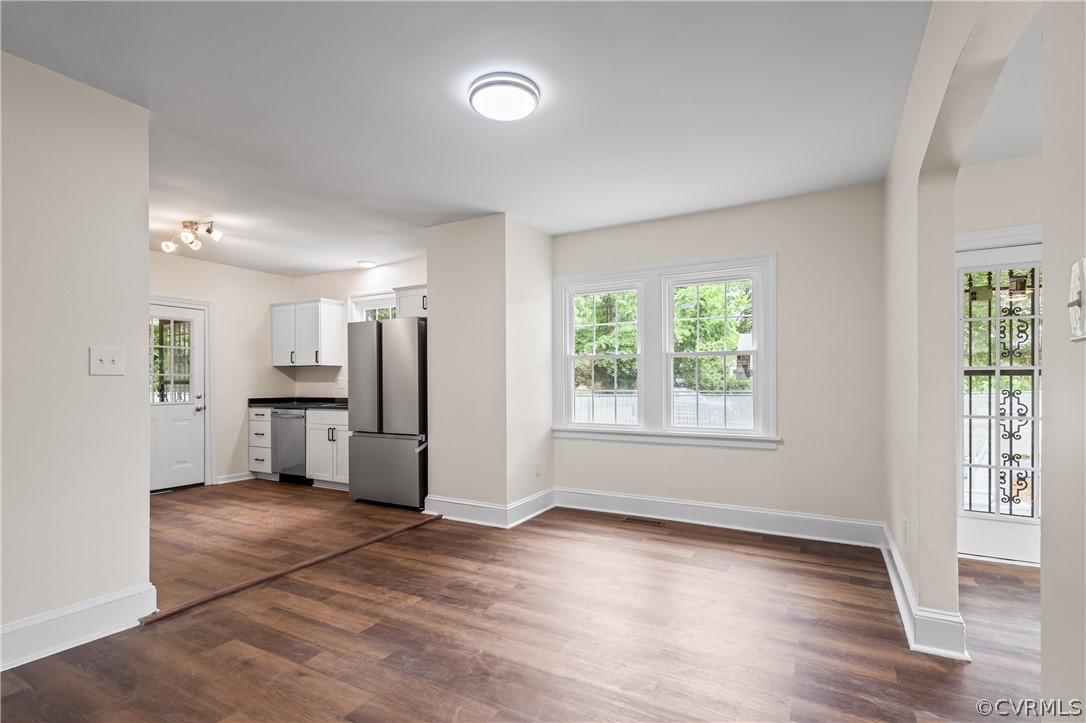 a view of a kitchen with refrigerator and wooden floor