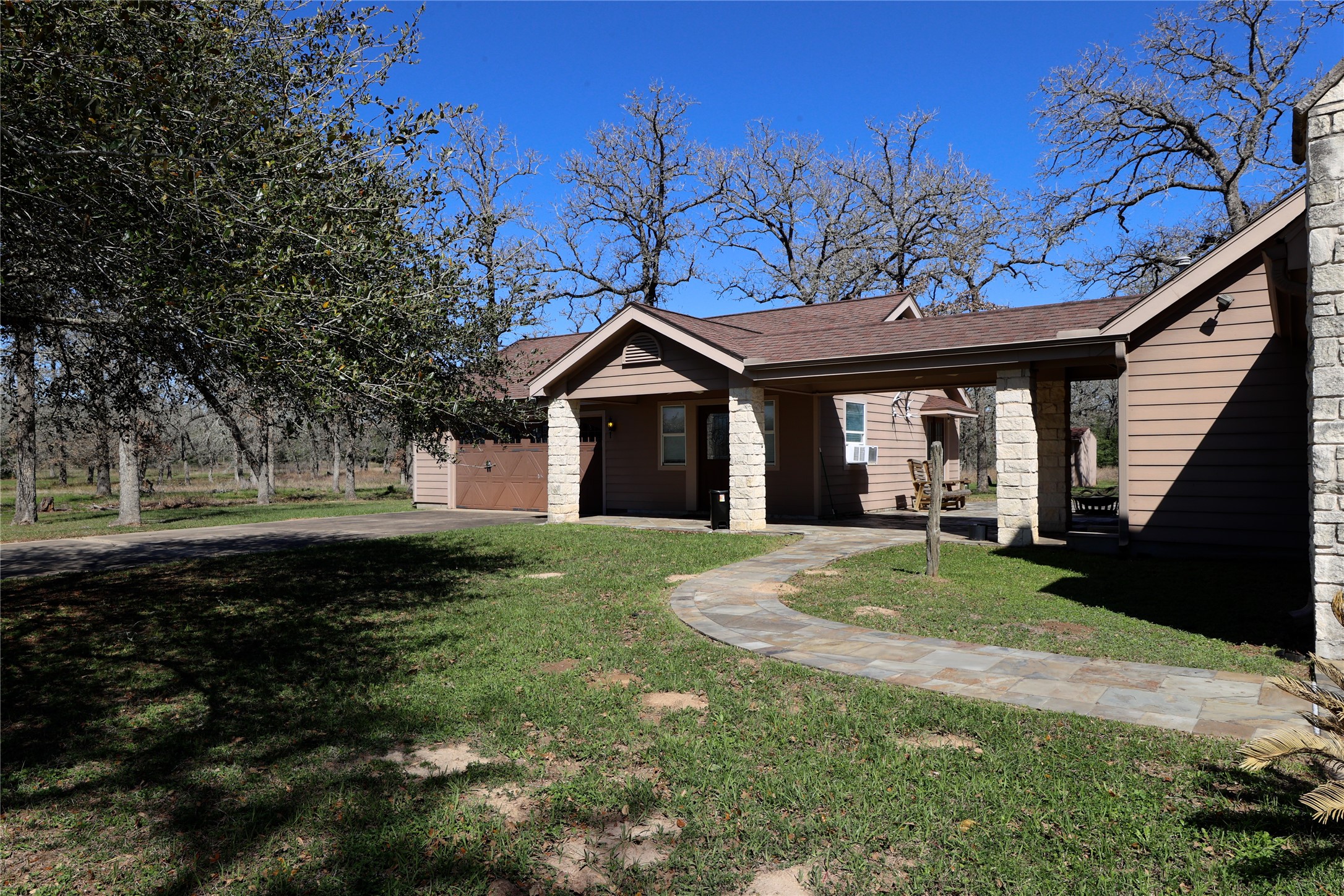 3337 Brunes Mill Road Columbus, TX 78934 - Photo 34 of 48 a large tree in front of a house with a garden