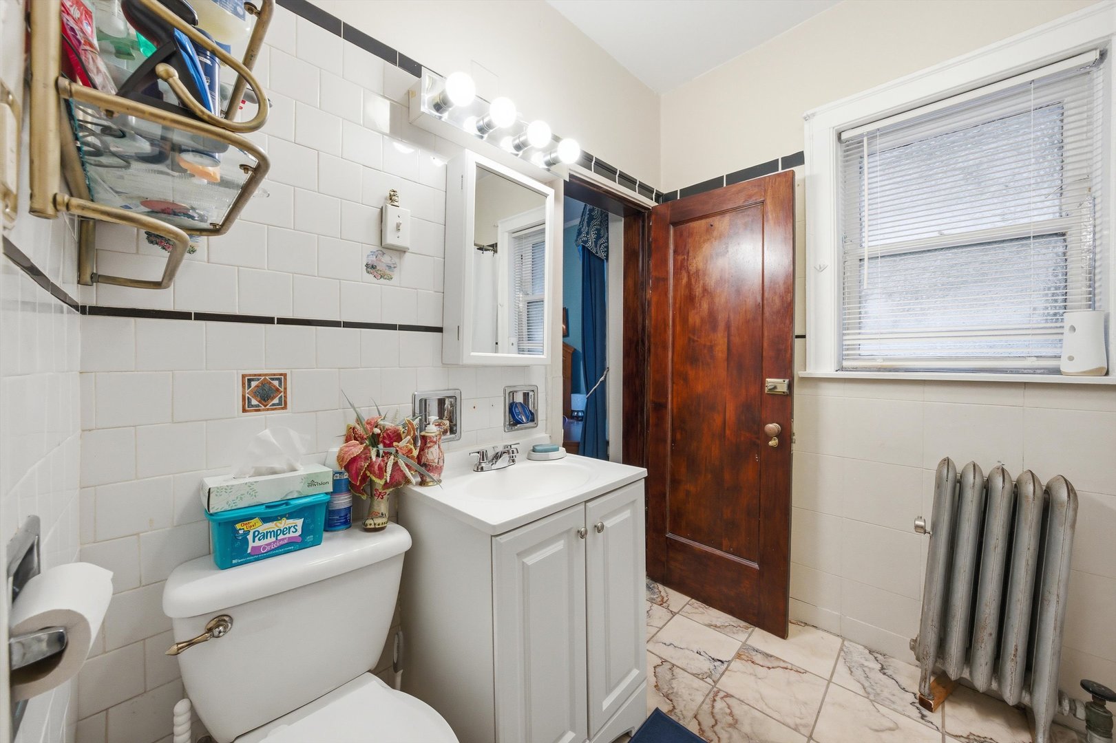 8019 South Rhodes Avenue Chicago, IL 60619 - Photo 16 of 55 a bathroom with a sink a toilet and shower curtain