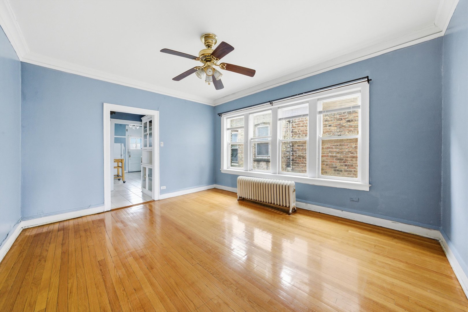 8019 South Rhodes Avenue Chicago, IL 60619 - Photo 23 of 55 a view of an empty room with a window and wooden floor