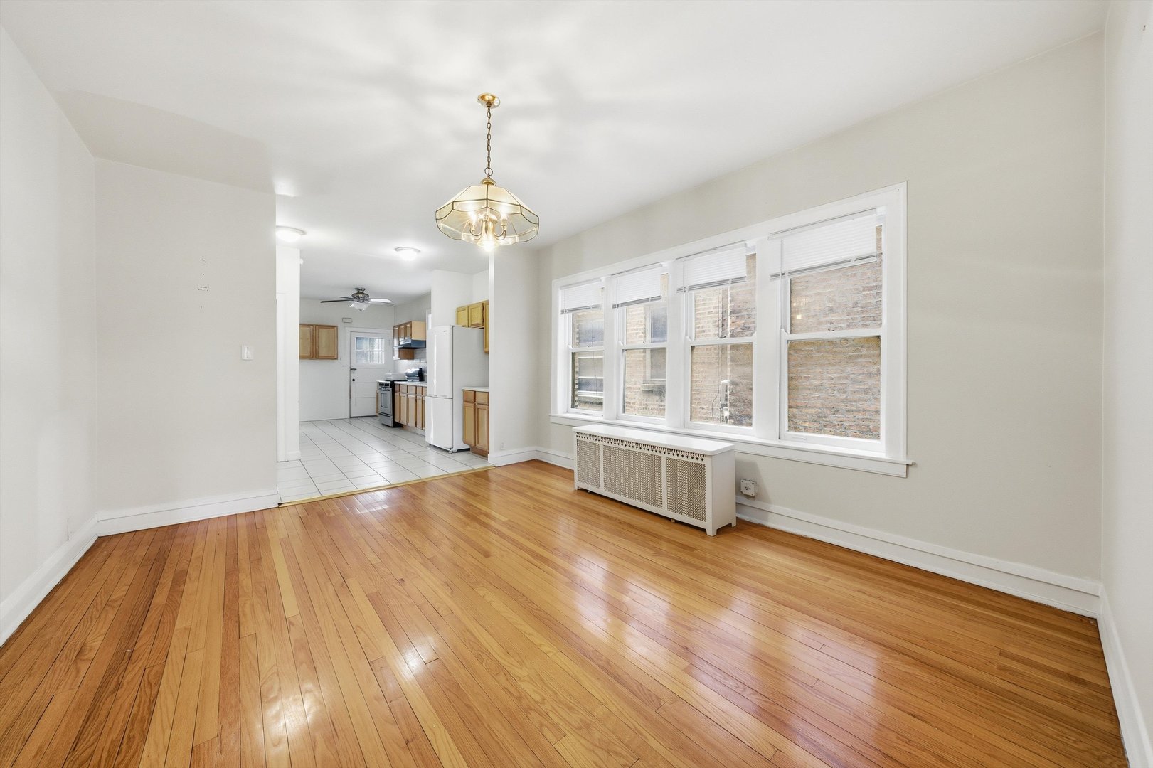 8019 South Rhodes Avenue Chicago, IL 60619 - Photo 35 of 55 a view of an empty room with a window and wooden floor