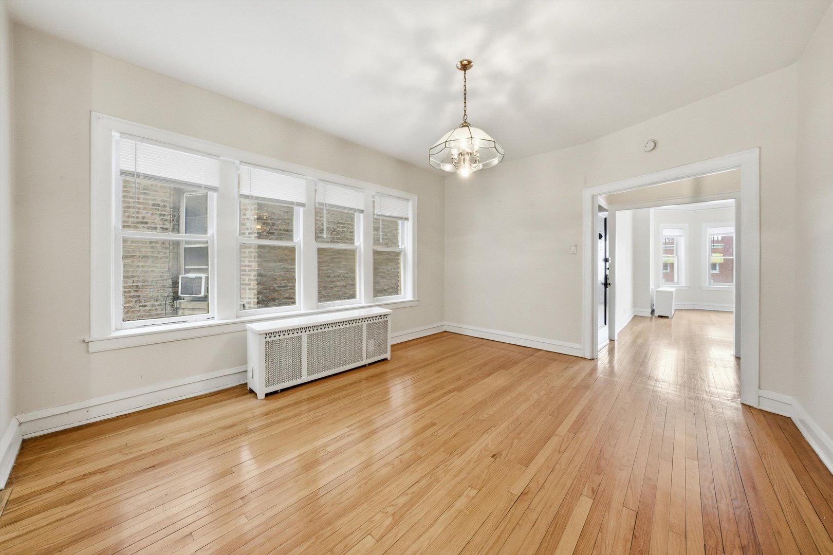 8019 South Rhodes Avenue Chicago, IL 60619 - Photo 37 of 55 a view of an empty room with wooden floor and a window