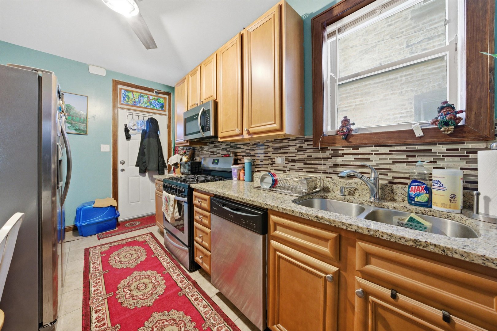 8019 South Rhodes Avenue Chicago, IL 60619 - Photo 8 of 55 a kitchen with stainless steel appliances granite countertop a sink and a refrigerator