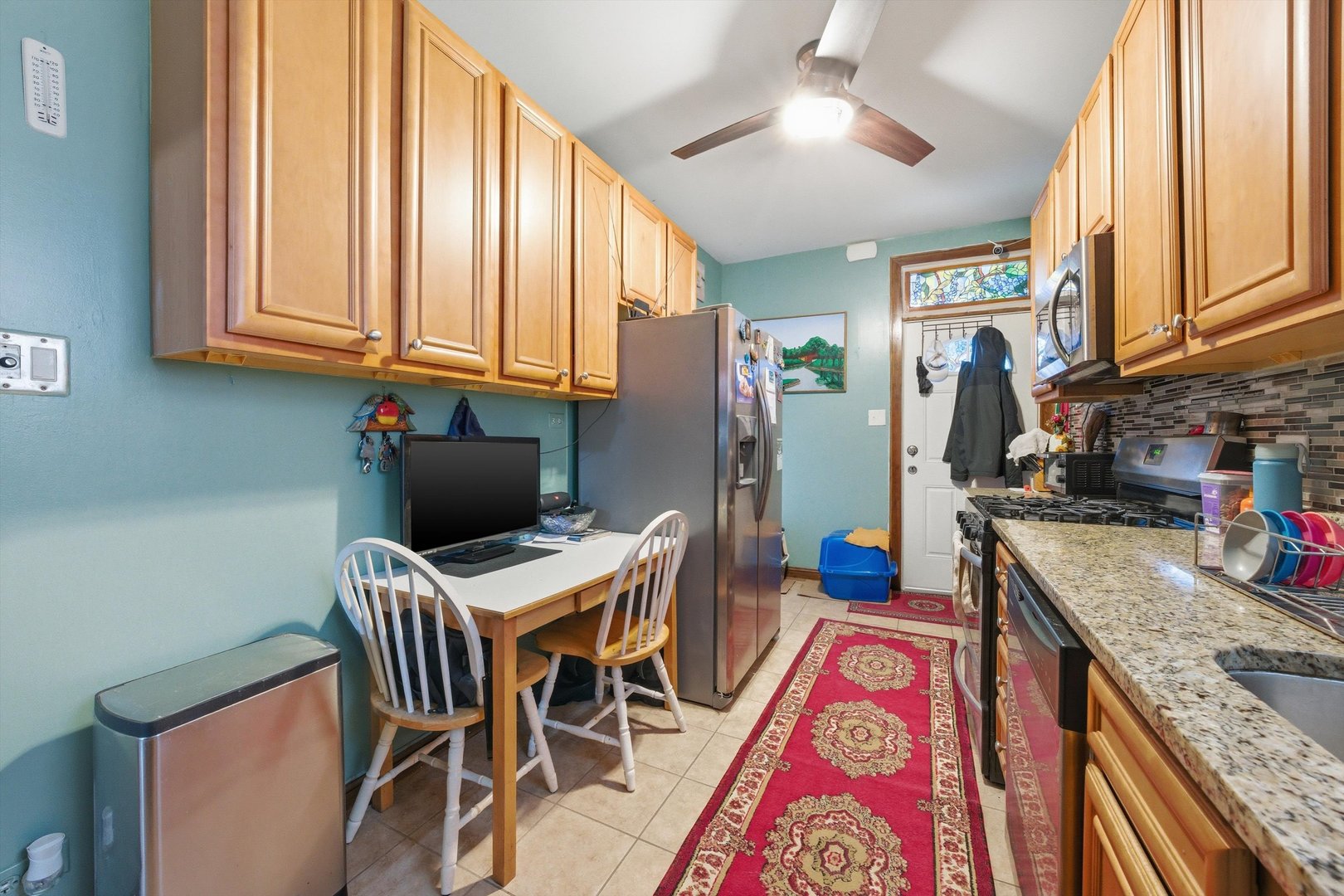 8019 South Rhodes Avenue Chicago, IL 60619 - Photo 9 of 55 a kitchen with stainless steel appliances granite countertop a refrigerator and a sink
