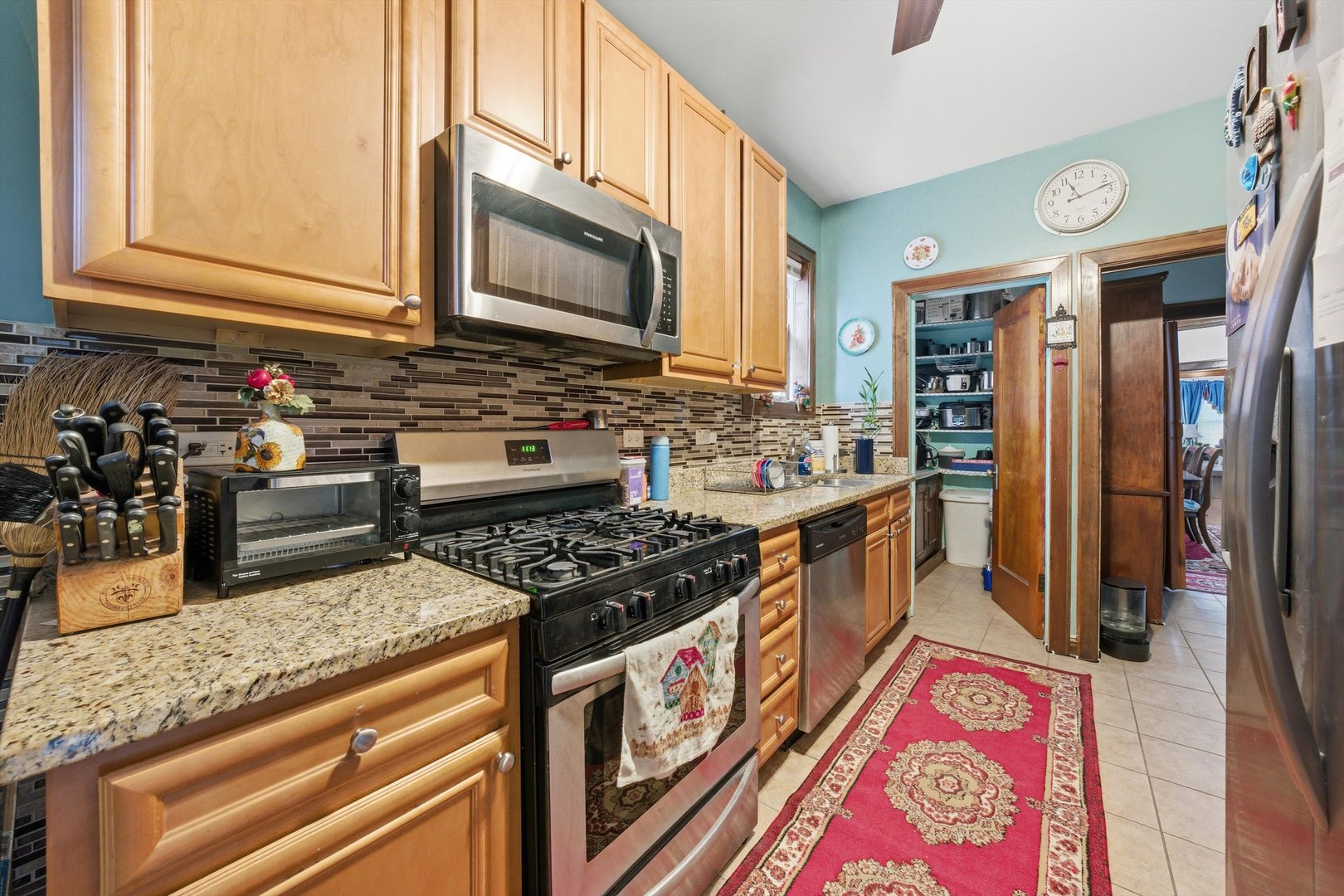 8019 South Rhodes Avenue Chicago, IL 60619 - Photo 10 of 55 a kitchen with stainless steel appliances granite countertop a stove a sink and a microwave