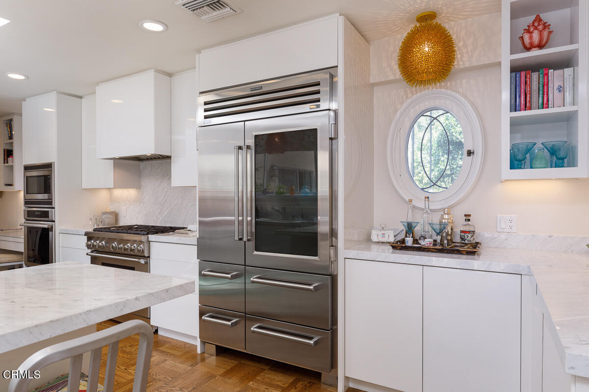 465 South San Rafael Avenue Pasadena, CA 91105 - Photo 24 of 75 a kitchen with stainless steel appliances a stove a chimney a sink and cabinets