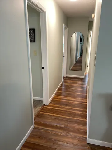 a view of a hallway with wooden floor and staircase