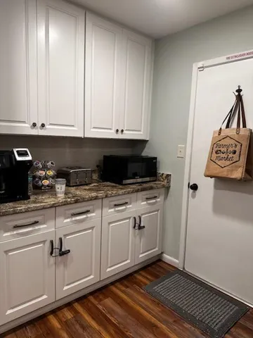 a kitchen with granite countertop a sink and cabinets