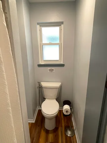 a bathroom with a toilet and a window