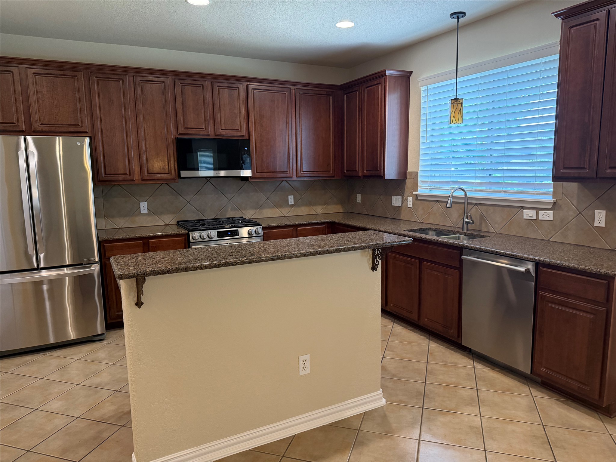 3021 Grand Mission Way Pflugerville, TX 78660 - Photo 12 of 31 A well-appointed kitchen showcasing rich cabinetry and practical counter space, perfect for culinary endeavors.
