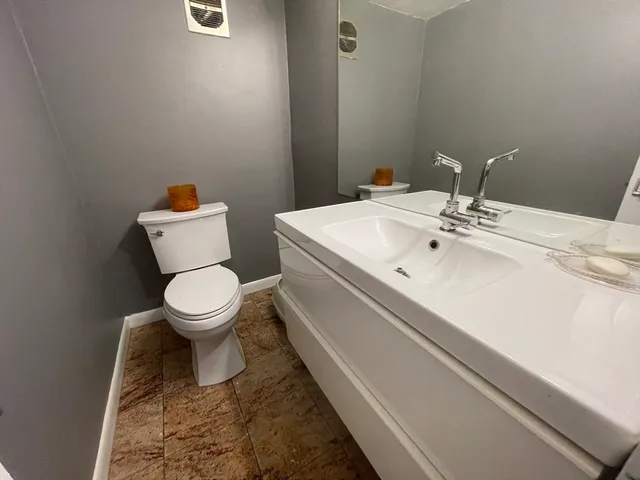 a bathroom with a sink mirror and toilet