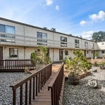 a balcony with wooden floor and outdoor seating