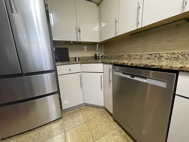 a kitchen with a refrigerator sink and cabinets