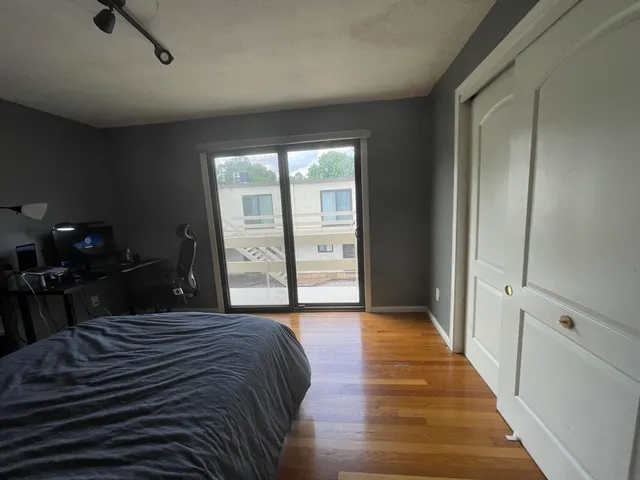 a bedroom with a bed and a lamp on dresser