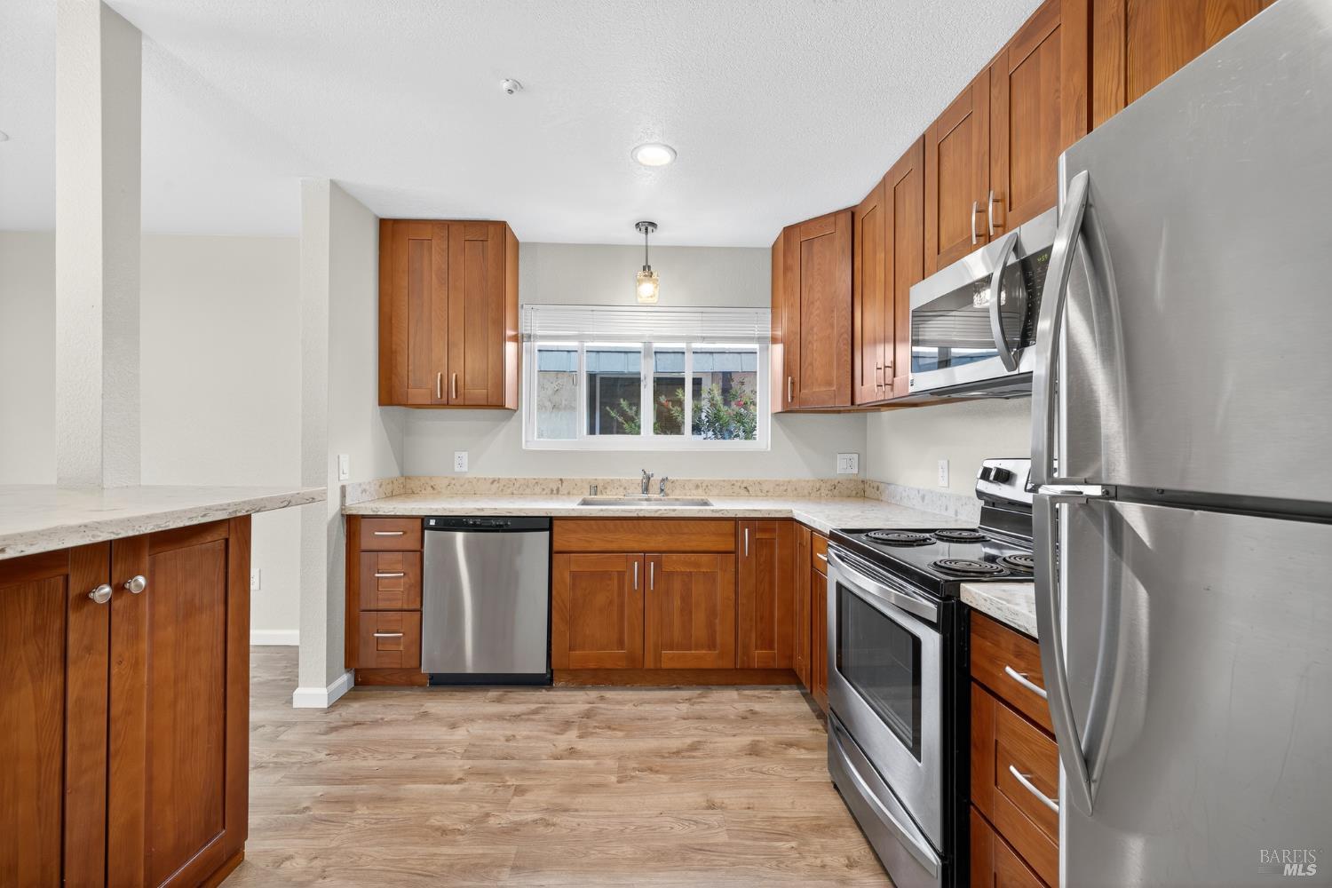 497 Sebastopol Avenue Santa Rosa, CA 95401 - Photo 12 of 42 a kitchen with stainless steel appliances granite countertop a refrigerator a sink dishwasher a stove and white cabinets with wooden floor