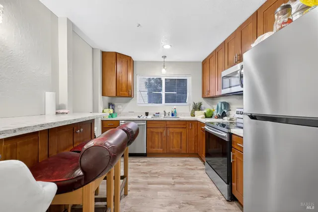 a kitchen with stainless steel appliances granite countertop a refrigerator sink and stove