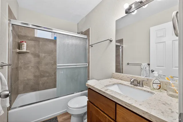 a bathroom with a granite countertop sink toilet and shower