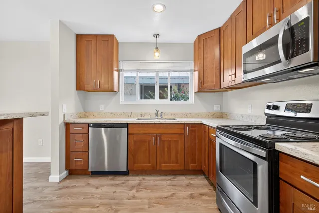 a kitchen with stainless steel appliances granite countertop a stove and a microwave