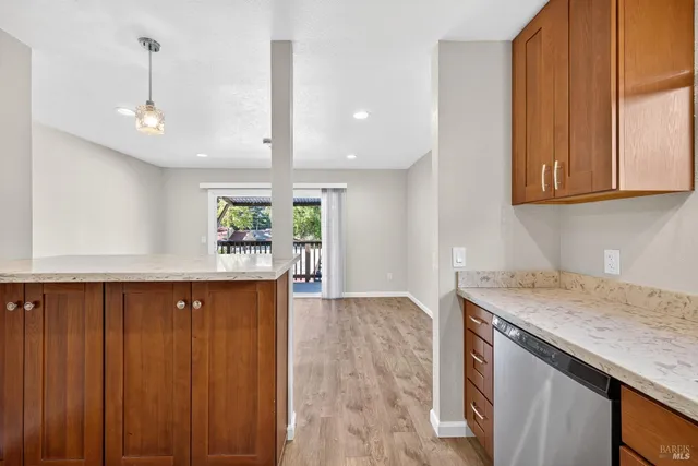 a kitchen with stainless steel appliances granite countertop wooden cabinets a window and a sink