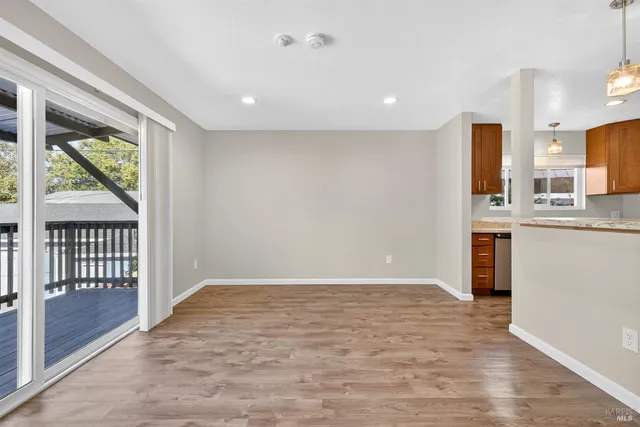 a view of a kitchen with wooden floor and a window