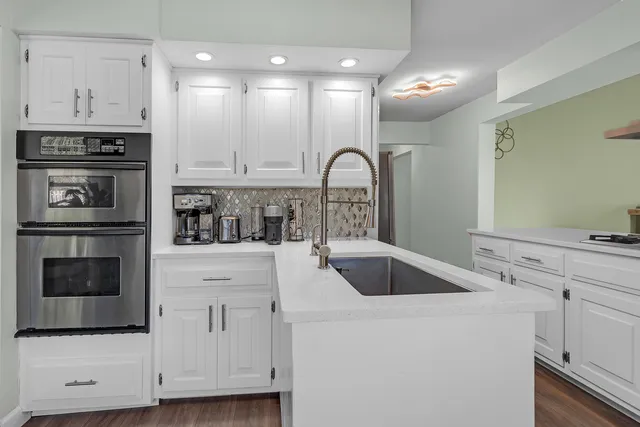a kitchen with white cabinets and stainless steel appliances