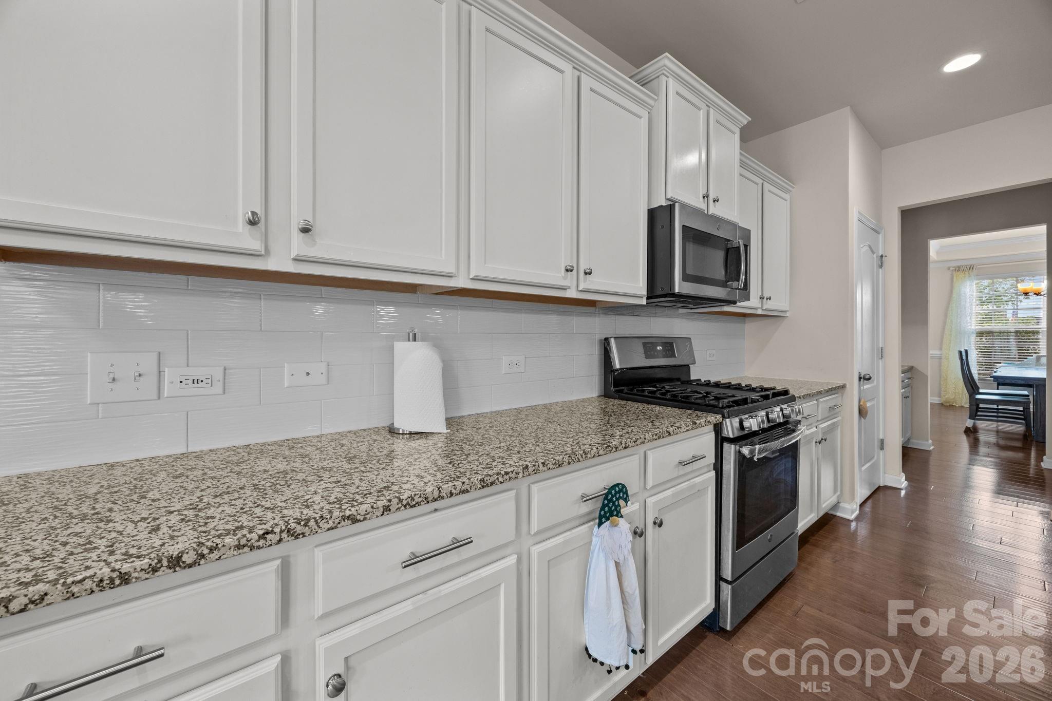 4028 Whittier Lane Tega Cay, SC 29708 - Photo 11 of 46 a kitchen with granite countertop white cabinets and stainless steel appliances