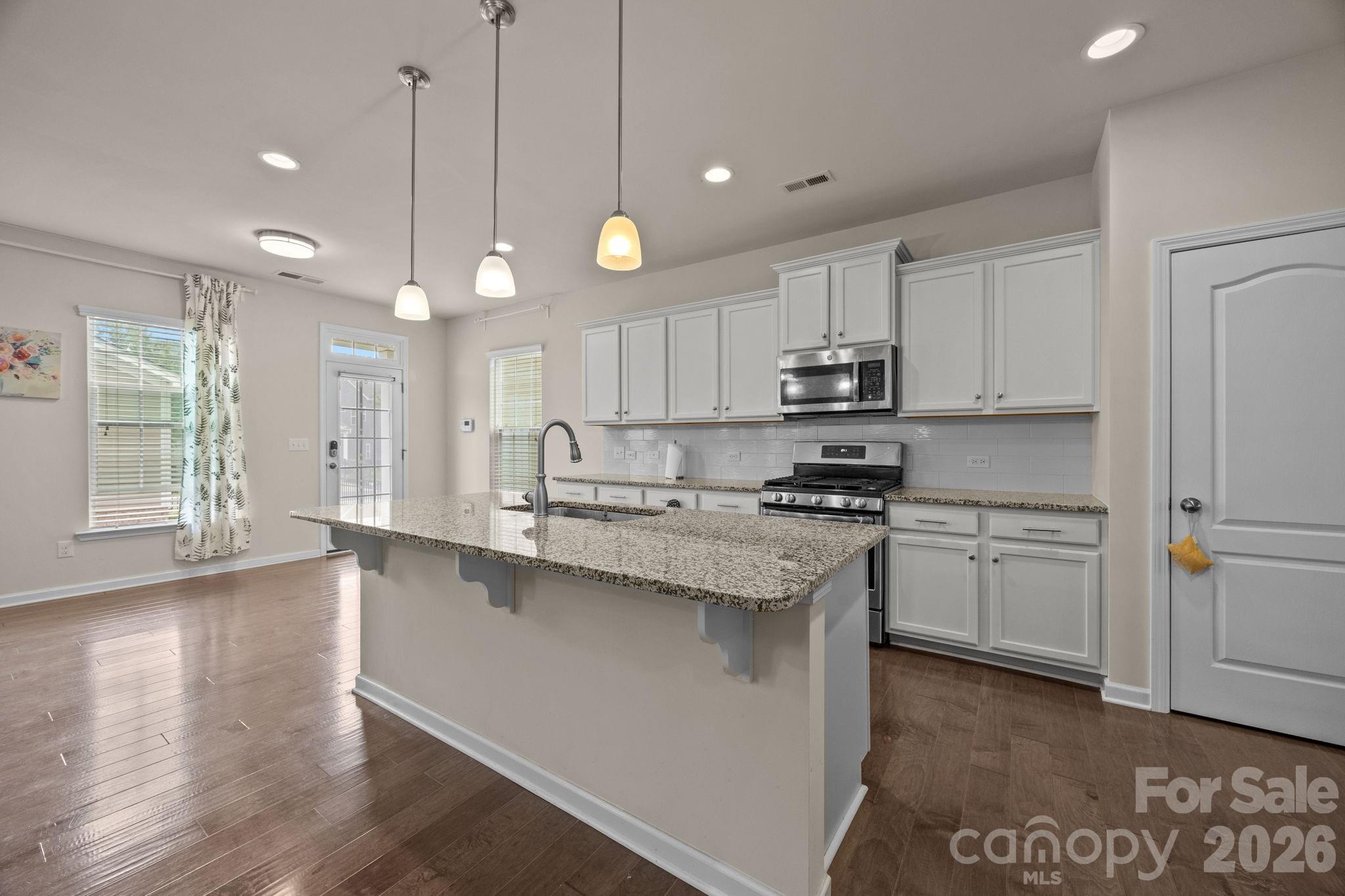 4028 Whittier Lane Tega Cay, SC 29708 - Photo 13 of 46 a kitchen with stainless steel appliances granite countertop a sink a stove a refrigerator and a microwave