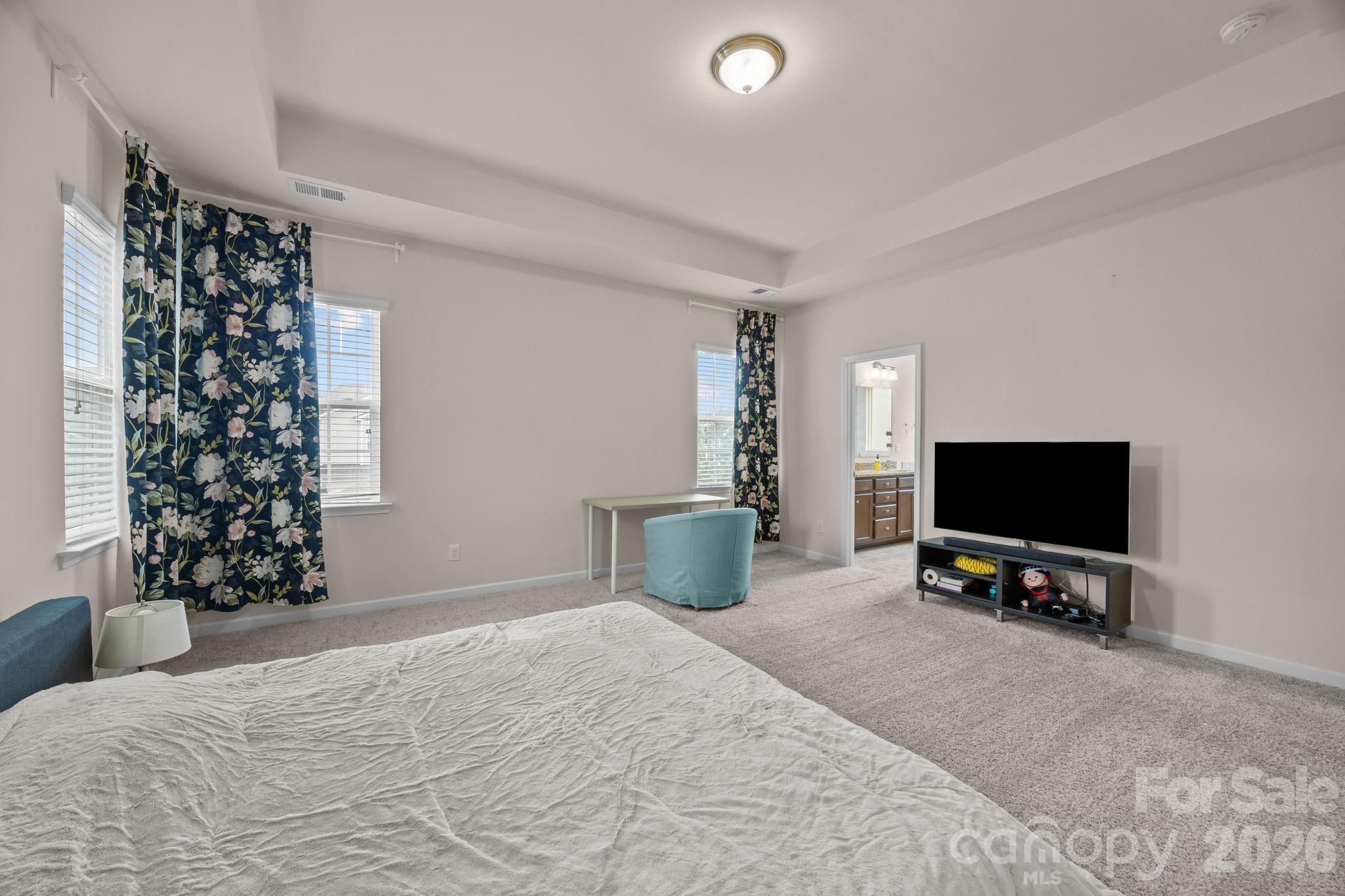 4028 Whittier Lane Tega Cay, SC 29708 - Photo 23 of 46 a bedroom with a bed and a flat tv screen on wall