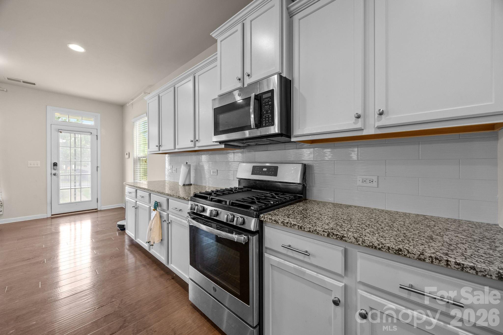 4028 Whittier Lane Tega Cay, SC 29708 - Photo 9 of 46 a kitchen with stainless steel appliances granite countertop a stove a sink and a microwave