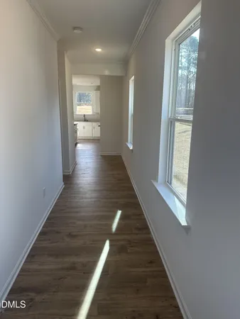 a view of a hallway with wooden floor and staircase