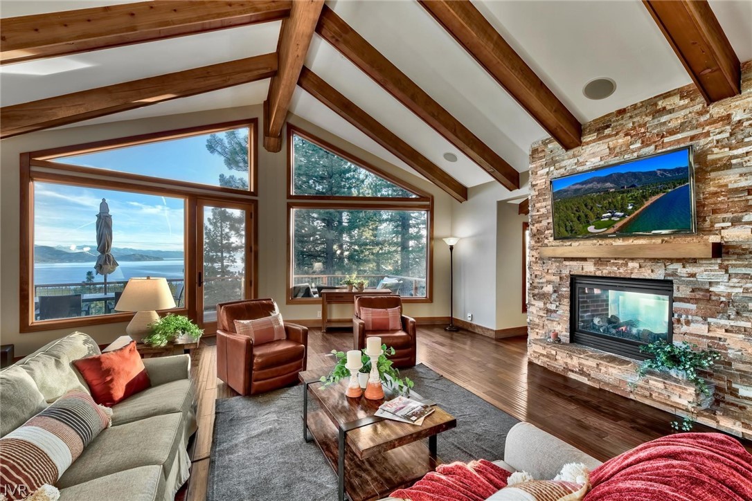 a living room with furniture a fireplace and a flat tv screen next to a window