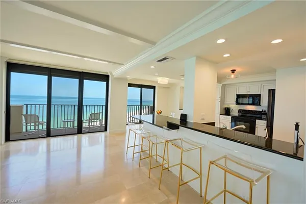 a view of a kitchen with kitchen island granite countertop a large window and a counter space