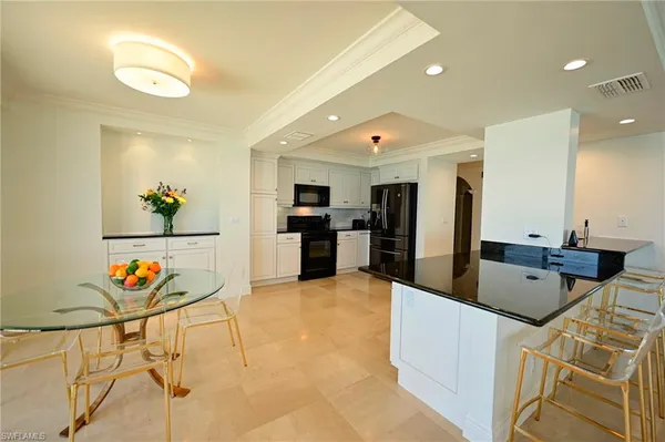 a large kitchen with stainless steel appliances granite countertop a sink and a refrigerator